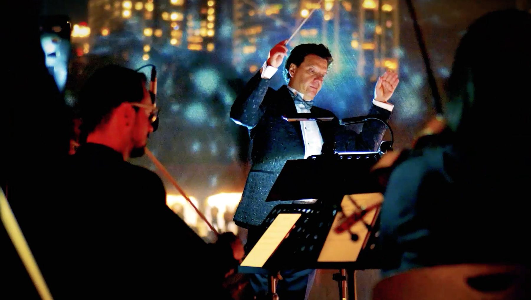 Maestro, engaged in conducting, with projection against the skyline